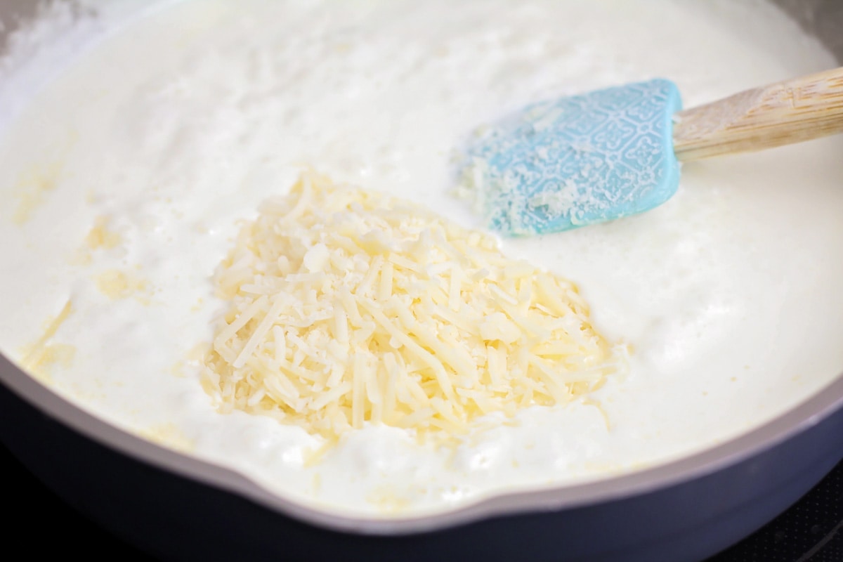 Ingredients for Alfredo sauce poured into skillet.