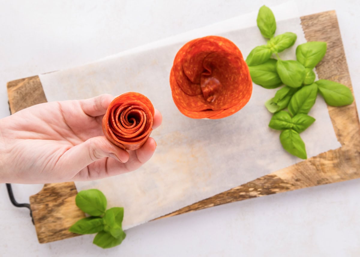 Rolling and placing a rolled pepperoni into a glass jar.