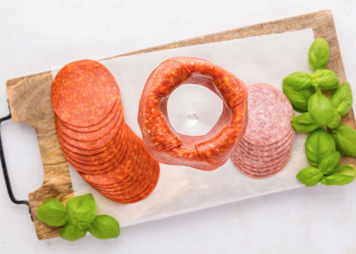 Placing pepperoni slices around the rim of the jar.