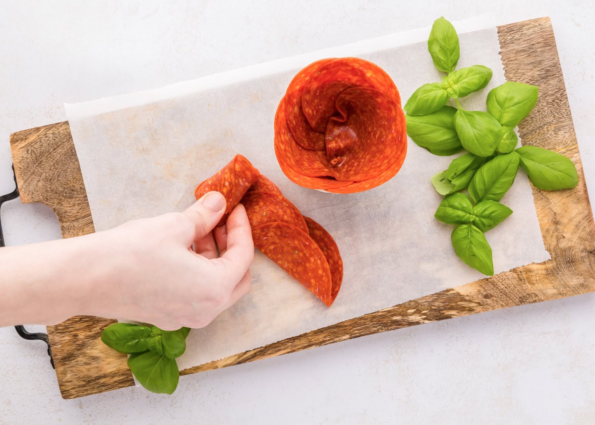 Folding and rolling pepperoni to place in a glass jar.