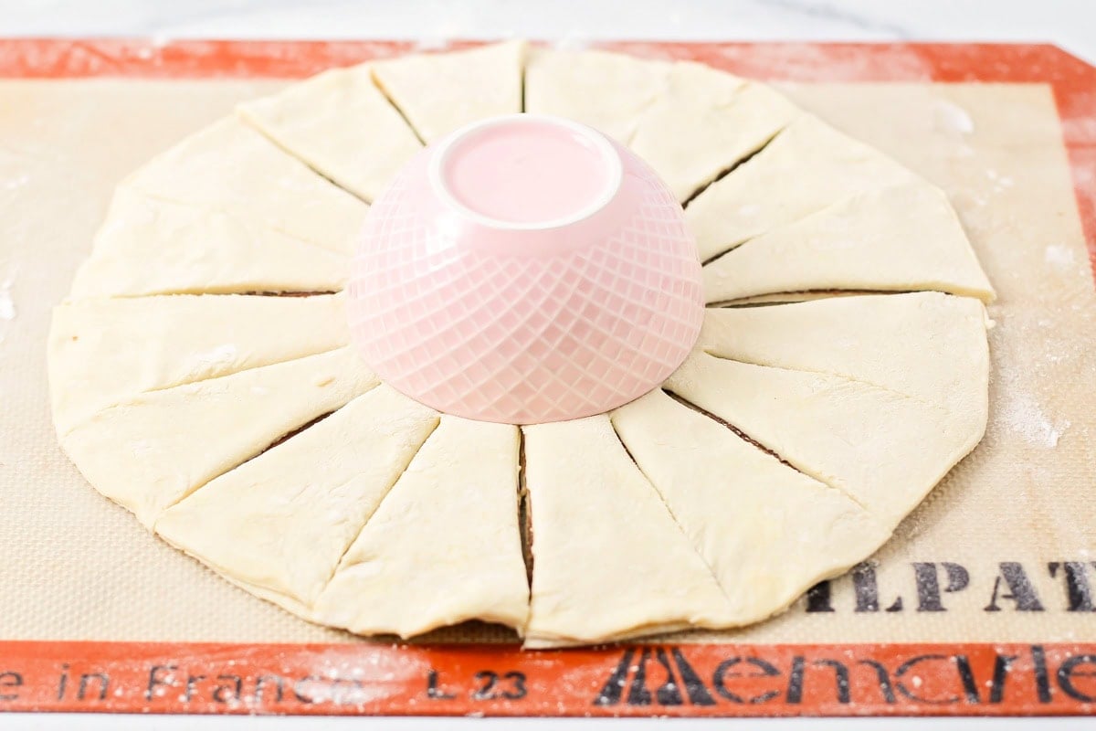 Cutting the strips from the center of the puff pastry round.